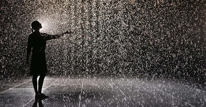 LONDON, ENGLAND - OCTOBER 03:  A woman experiences the 'Rain Room' art installation by 'Random International' in The Curve at the Barbican Centre on October 3, 2012 in London, England. The 'Rain Room' is a 100 square meter field of falling water which visitors are invited to walk into with sensors detecting where the visitor are standing. The installation opens to the public on October 4, 2012 and runs until March 3, 2013.  (Photo by Oli Scarff/Getty Images)